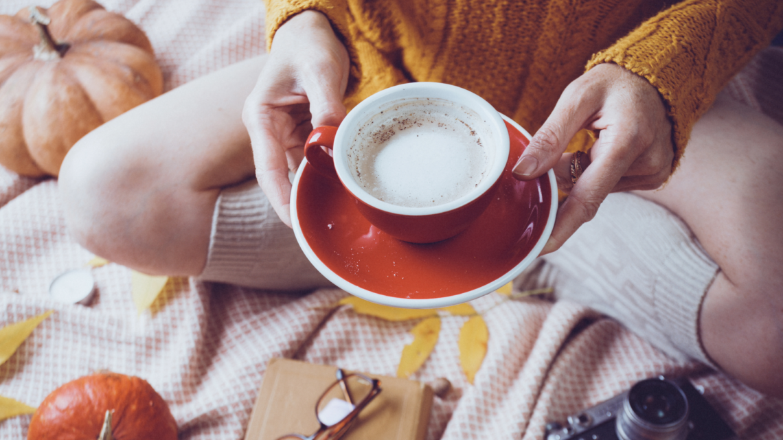 Girl holding coffee mug on bed