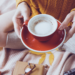 Girl holding coffee mug on bed