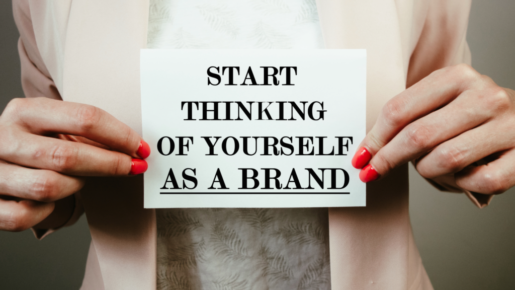 Person holding sign saying "start thinking of yourself as a brand"